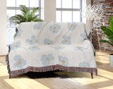 Atia Cheetah Print Cotton Throw Blanket in Light Blue and Beige, draped over a sofa