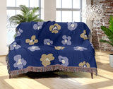Atia Cheetah Print Cotton Throw Blanket in Navy Blue and Beige, draped over a sofa