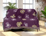 Atia Cheetah Print Cotton Throw Blanket in Purple and Beige, draped over a sofa
