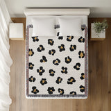 Atia Cheetah Print Cotton Throw Blanket in Off-White, Black and Beige, on a bed