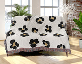 Atia Cheetah Print Cotton Throw Blanket in Off-White, Black and Beige, draped over a sofa