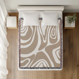 Binitie Zebra Print Cotton Throw Blanket in Beige, on a bed