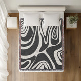Binitie Zebra Print Cotton Throw Blanket in Gray, on a bed