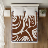 Binitie Zebra Print Cotton Throw Blanket in Rust Brown, on a bed