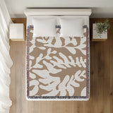 Booker Floral Cotton Throw Blanket in Beige, on a bed