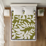 Booker Floral Cotton Throw Blanket in Chartreuse, on a bed