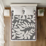 Booker Floral Cotton Throw Blanket in Gray, on a bed
