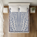 Buga Abstract Print Cotton Throw Blanket in Light Blue, on a bed