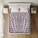 Buga Abstract Print Cotton Throw Blanket in Purple, on a bed