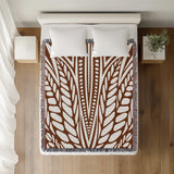 Buga Abstract Print Cotton Throw Blanket in Rust Brown, on a bed