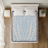 Buga Abstract Print Cotton Throw Blanket in Sky Blue, on a bed