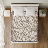 Caro Floral Cotton Throw Blanket in Beige, on a bed