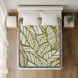 Caro Floral Cotton Throw Blanket in Chartreuse, on a bed