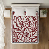 Caro Floral Cotton Throw Blanket in Red, on a bed