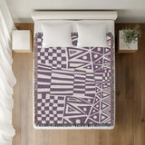 Cocodili Abstract Print Cotton Throw Blanket in Purple, on a bed