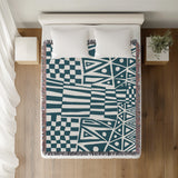 Cocodili Abstract Print Cotton Throw Blanket in Teal, on a bed