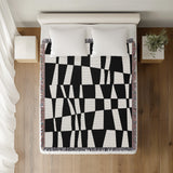 Colette Checkered Cotton Throw Blanket in Black, on a bed