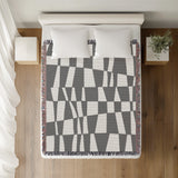 Colette Checkered Cotton Throw Blanket in Gray, on a bed