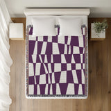 Colette Checkered Cotton Throw Blanket in Purple, on a bed