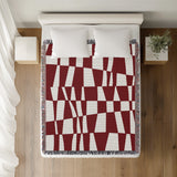 Colette Checkered Cotton Throw Blanket in Red, on a bed