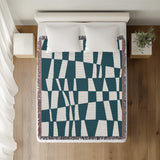 Colette Checkered Cotton Throw Blanket in Teal, on a bed