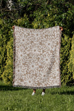 Dandelion Floral Cotton Throw Blanket in Beige, outdoors