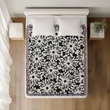 Dandelion Floral Cotton Throw Blanket in Black, on a bed
