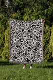 Dandelion Floral Cotton Throw Blanket in Black, outdoors