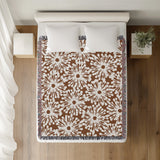 Dandelion Floral Cotton Throw Blanket in Rust Brown, on a bed