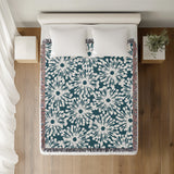 Dandelion Floral Cotton Throw Blanket in Teal, on a bed
