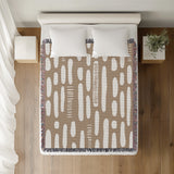 Deka Abstract Cotton Throw Blanket in Beige, on a bed