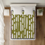 Deka Abstract Cotton Throw Blanket in Chartreuse, on a bed