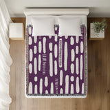 Deka Abstract Cotton Throw Blanket in Purple, on a bed