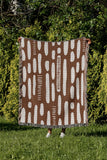 Deka Abstract Cotton Throw Blanket in Rust Brown, outdoors