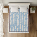 Deka Abstract Cotton Throw Blanket in Sky, on a bed