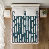 Deka Abstract Cotton Throw Blanket in Teal, on a bed