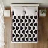 Demi Geometric Cotton Throw Blanket in Black, on a bed