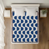 Demi Geometric Cotton Throw Blanket in Blue, on a bed