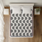 Demi Geometric Cotton Throw Blanket in Gray, on a bed