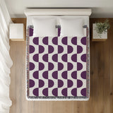Demi Geometric Cotton Throw Blanket in Purple, on a bed