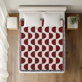 Demi Geometric Cotton Throw Blanket in Red, on a bed