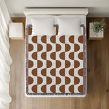 Demi Geometric Cotton Throw Blanket in Rust Brown, on a bed