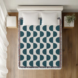 Demi Geometric Cotton Throw Blanket in Teal, on a bed