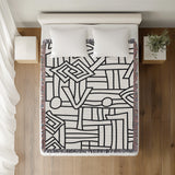 Diof Abstract Print Cotton Throw Blanket in Black, on a bed