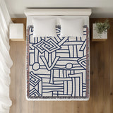 Diof Abstract Print Cotton Throw Blanket in Navy Blue, on a bed