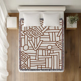 Diof Abstract Print Cotton Throw Blanket in Rust Brown, on a bed