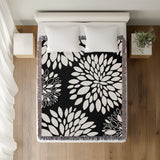 Fiesta Floral Cotton Throw Blanket in Black, on a bed