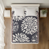 Fiesta Floral Cotton Throw Blanket in Gray, on a bed