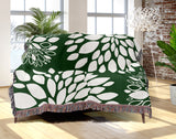 Fiesta Floral Cotton Throw Blanket in Green, draped over a sofa