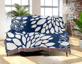 Fiesta Floral Cotton Throw Blanket in Navy Blue, draped over a sofa